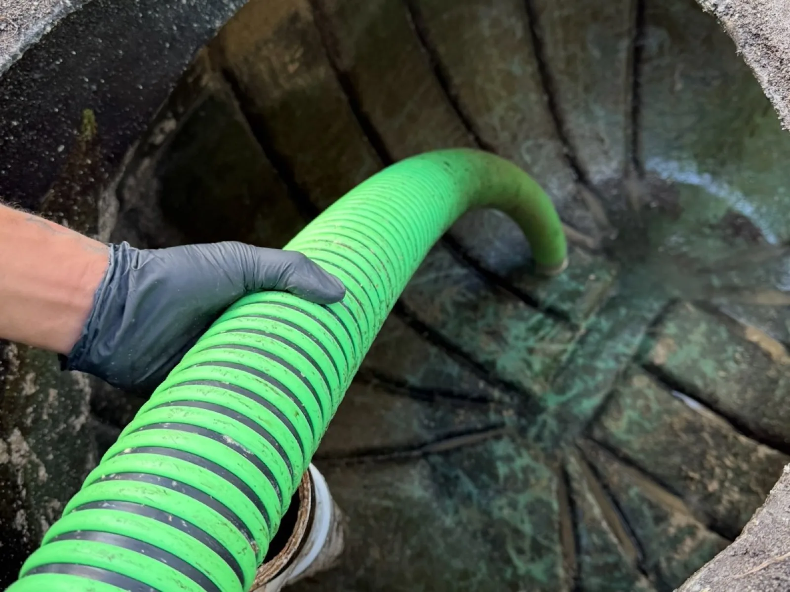 Vacuum hose run to a below-grade access point during a pump-out